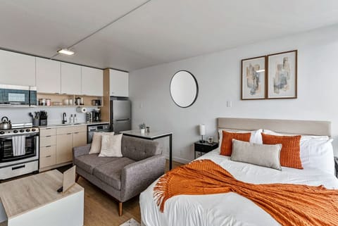 Open-concept studio w/ cozy sofa, bed & kitchenette for a comfortable all-in-one stay