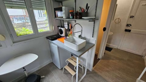 Kitchenette ouverte sur l'espace chambre, équipée avec plaque de cuisson, machine à café, micro-ondes et petit réfrigérateur.