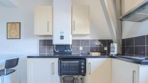 Cuisine équipée avec petit réfrigérateur, machine à café, bouilloire, plaques de cuisson et micro-ondes faisant four.
Coin repas pour 2 personnes.