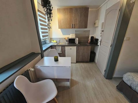 Cuisine équipée avec petit réfrigérateur, machine à café, bouilloire, plaques de cuisson et micro-ondes.
Coin salle-à-manger pour deux personnes.
La cuisine est ouverte sur l'espace salon.