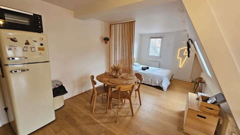 Chambre avec lit double et télévision murale HD.
Chambre semi ouverte sur l'espace repas pour deux personnes et la cuisine.