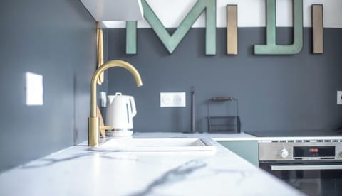 Cuisine équipée avec four, plaques de cuisson, machine à café, bouilloire, réfrigérateur avec partie congélateur, lave-vaisselle, machine à laver et micro-ondes.