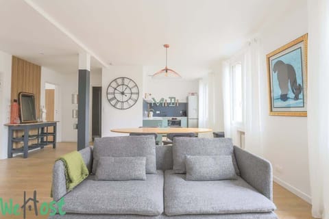 Salon avec TV HD et espace salle-à-manger, ouvert sur la cuisine.