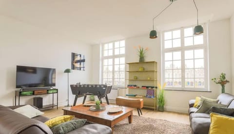 Salon avec 3 grands canapés, TV HD Système son, baby-foot et jeux de société.

Vue magnifique sur la Grand Place.