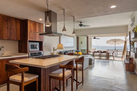 A sleek and functional kitchen featuring high-end appliances, stylish pendant lighting, and a spacious breakfast bar.