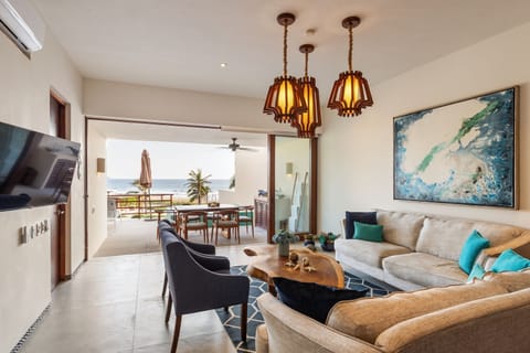 A beautifully designed open-concept living and dining area with elegant decor, cozy seating, and breathtaking ocean views.