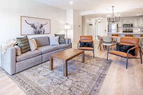 Living room with comfortable seating and TV, open to the kitchen and dining area. Home professionally cleaned prior to arrival.