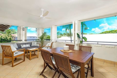 The covered terrace offers an outdoor dining setting and lounge seating with views across the resort gardens, ideal for long lunches and slow evenings.