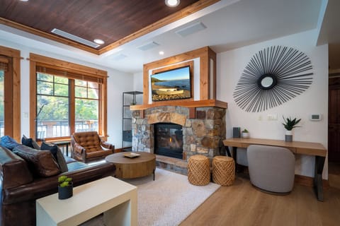 Cozy mountain modern living room with stone fireplace and desk
