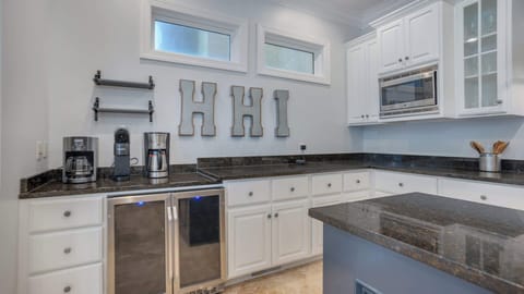 This stylish kitchen boasts a full array of appliances and a spacious layout, making it a chef's dream. The bar seating offers a casual dining option, allowing guests to gather and chat while enjoying delicious meals prepared right at home
