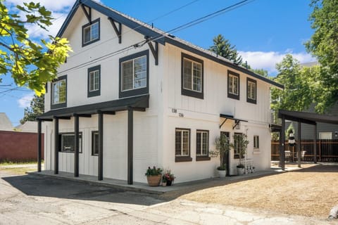 Charming black-and-white duplex with carport and sunny windows