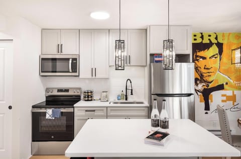 Dine in style with a beautiful crystal chandelier above, accompanied by iconic Bruce Lee wall art for a unique dining experience.