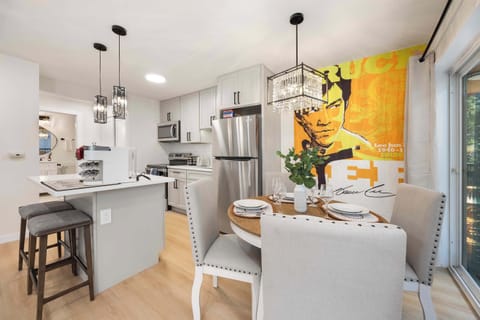 Dine in style in this modern, well-lit space featuring chic urban décor with a striking pop art centerpiece, sleek kitchen, and a view into the airy outdoor area.