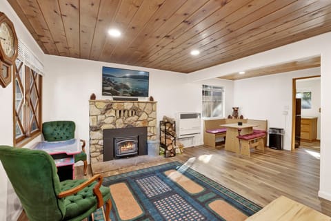 Cozy mountain living room with a stone fireplace, comfy seating, and smart TV—perfect for relaxing evenings, movie nights, and warm cabin vibes after outdoor adventures.
