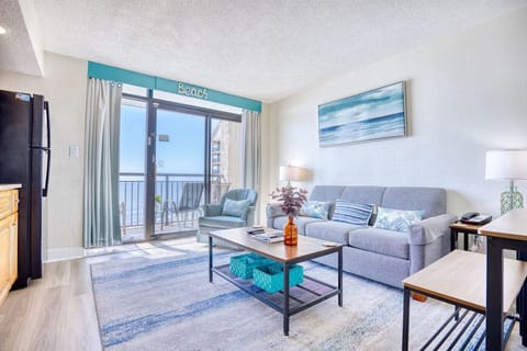 Living Room with Sofa Sleeper & Ocean Views: Relax in a comfortable living room with a cozy sofa sleeper, leading to a oceanfront balcony. Take in panoramic views of North Myrtle Beach`s coastline and enjoy the beachfront pools in a tropical resort.