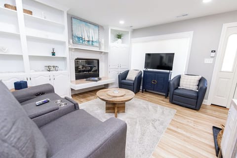 Comfortable family room with reclining sofa, Smart TV and remote controlled window shades.