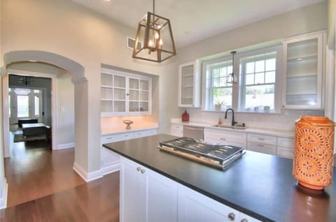 Kitchen island with gas cooktop. View through butlers pantry arch to front door