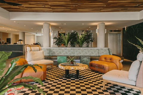 This spacious and vibrant lobby, with its bold patterns and inviting seating, creates the perfect spot to relax and unwind in a lively atmosphere.