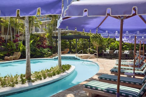 Bask in the tropical ambiance by the pool, where shaded loungers and lush greenery create the perfect setting for a relaxing day in the sun.