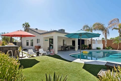 Sparkling heated optional pool, sun loungers, custom-built BBQ area, mobile cooler, cornhole, floating basketball hoop, outdoor dining table, patio furniture, and ample lounge areas.