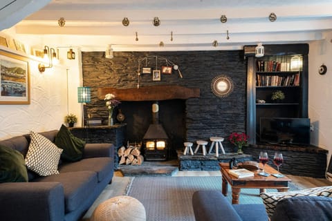 Lounge with sofas, coffee table, TV, fireplace with wood burner