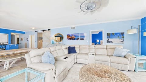 Open concept living area with huge couch and TV