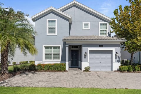 This charming light blue home, surrounded by lush greenery, creates a warm first impression. The inviting porch and lovely landscaping promise a delightful stay in this vibrant setting.
