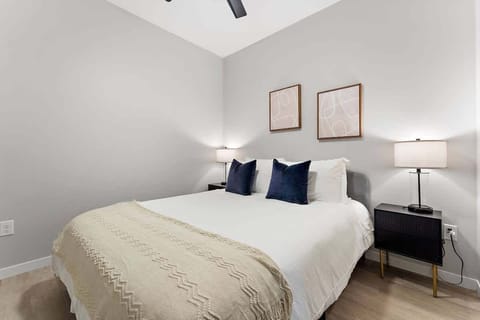 Relax in this serene bedroom with soft tones, cozy bedding, and modern accents.