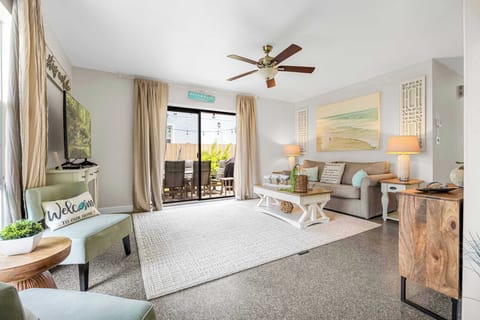 Relax in this bright living room with coastal decor and direct access to a private outdoor patio.