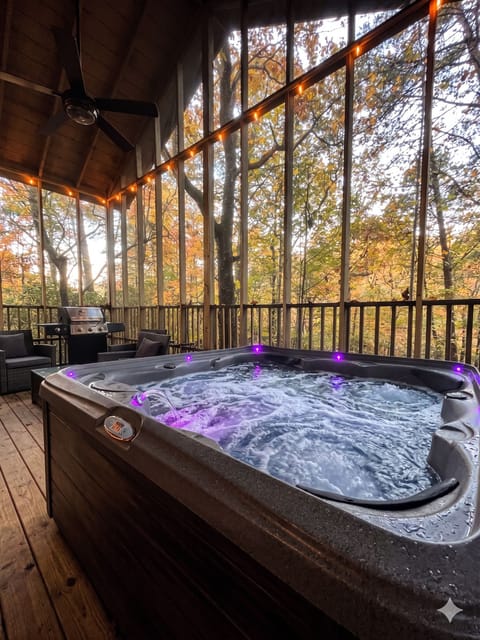 Sink into the screened-porch hot tub with the string lights on and the fall foliage glowing through the screen — soak in any weather, bug-free, glass of wine in hand. This is the longest exhale of your week.