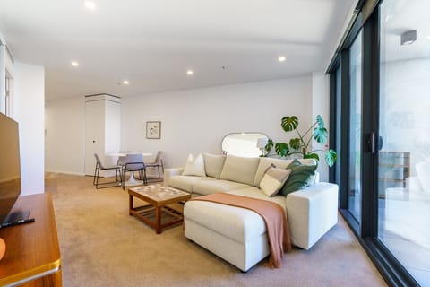 Settle into the inviting lounge area, featuring a plush sofa and smart TV for entertainment.