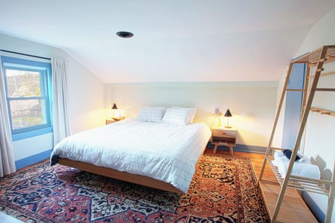 Blackout curtains, wardrobe, dresser, desk, TV, and a king-size bed