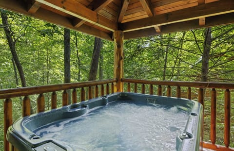 Covered hot tub surrounded by nature with hammocks and outdoor furniture