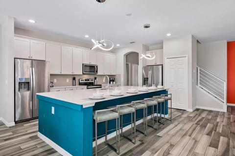- Spacious modern kitchen with island and bar seating  
- Orlando vacation rental with chef style gourmet setup  
- Perfect villa near Disney for family meals together