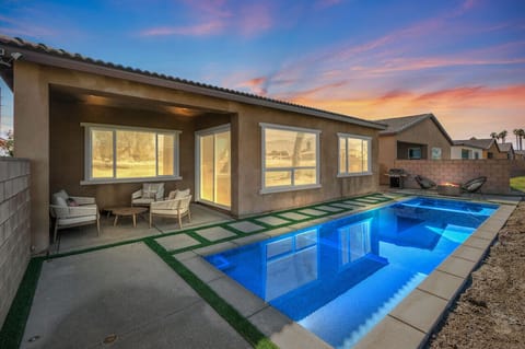 Unwind by the sparkling backyard pool at sunset, w/ a covered patio perfect for evening lounging.