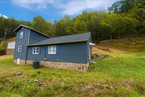 Blue cabin exterior and mountain setting on 37+ private acres