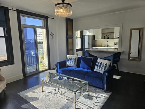 Living room with open kitchen floor plan leading onto the sunny balcony. 