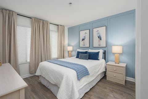 Where coastal charm meets refined comfort. This inviting queen suite showcases a custom accent wall, plush bedding, and calming hues that create the perfect setting to unwind after a day by the beach.