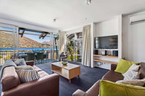 Open-plan living with comfortable sofas, TV, and lake-facing views