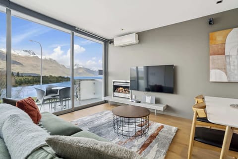 Living Room with a View – Floor-to-ceiling windows showcasing the lake and surrounding peaks.