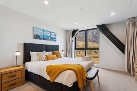 Bright bedroom with floor-to-ceiling windows and mountain views