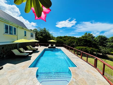 Large pool with relaxing soft lounge chaise and umbrellas