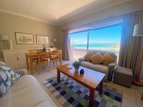 Open plan dining and living room that opens onto the private balcony overlooking Fish Hoek Beach. You are able to have a BBQ on this balcony weather dependant. 