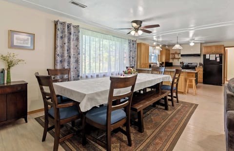 Large 12-piece dining set in the dining area of White Oaks Haven, with a commanding view of the spacious backyard through the huge picture window.