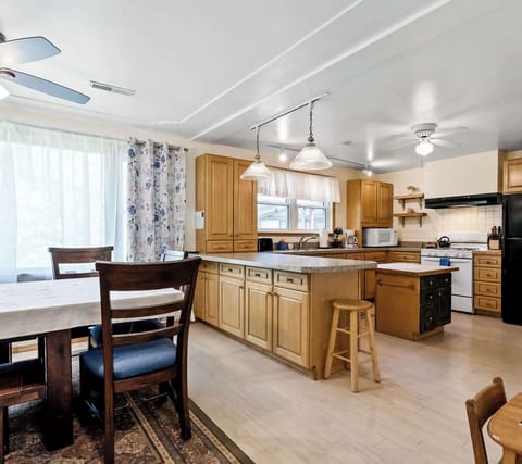 Wide view of the White Oaks Haven kitchen area and part of the dining table, as seen from the living room lounge area