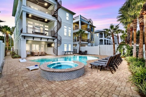 Sunset Manor—your perfect group getaway that SLEEPS 26! Just steps from PRIVATE beach access, this stunning retreat includes a FREE golf cart. Unwind in the backyard oasis with a heated pool, hot tub, outdoor kitchen, and lounge seating. Plus a game room!