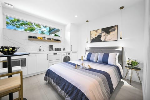 Bright, modern studio with integrated kitchen, cozy bed, and stylish decor.