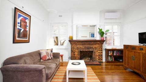 Cozy up in a character-filled lounge featuring gorgeous polished timber floors and a classic brick fireplace.