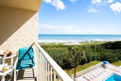 Private balcony retreat with seating and panoramic coastal scenery.