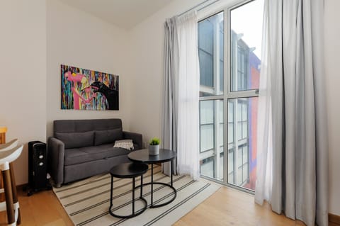 Bright lounge corner with comfortable seating and floor-to-ceiling windows.
